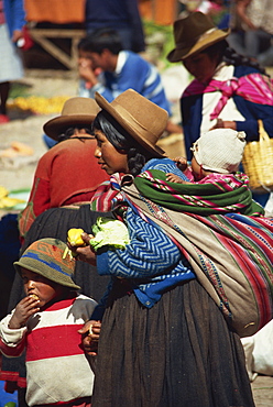 Portrait of a woman in a felt hat with her children in the Sunday market at Pisac in Peru, South America