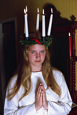 Teenage girl praying in traditional costume, for Santa Lucia Day 13, marking the shortest day of the year, a very important Swedish day, Gothenburg, Sweden, Scandinavia, Europe