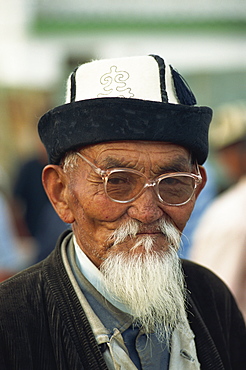 Portrait of an old Kirghiz man with white beard, felt hat and glasses at the horse market at Balikchi in Kyrgyzstan, Central Asia, Asia