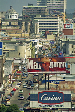 View down 7 Avenida with advertising signs and buildings in Guatemala City, Guatemala, Central America