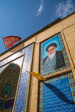 Imam Khomeini looks down from the facade of a small mosque in the backstreets, Shiraz, Iran, Middle East