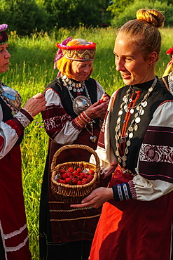 Seto girl offers wild strawberries to friends, Feast Day, Uusvada, Setomaa, SE Estonia, Europe