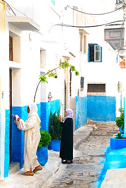 Two woman in local dress at neighbouring front doors, Kasbah des Oudaias, UNESCO World Heritage Site, Rabat, Morocco, North Africa, Africa