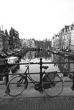 Black and white image of an old bicycle by the Singel canal, Amsterdam, Netherlands, Europe