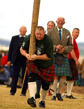 Tossing the caber at Montrose Highland Games, watched by Judge Sandy Gray in kilt, Montrose, Angus, Scotland, United Kingdom, Europe