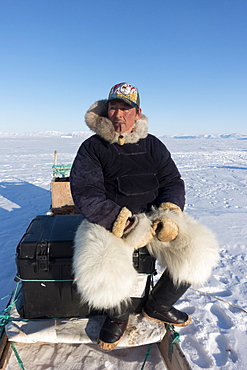 Inuit hunter smoking a pipe on the sea ice near Herbert Island, Greenland, Denmark, Polar Regions