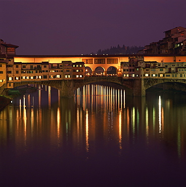 Reflections in the River Arno of lights on the Ponte Vecchio bridge at dusk in the town of Florence, UNESCO World Heritage Site, Tuscany, Italy, Europe