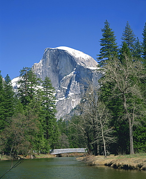 Trees beside a river frame the snow capped Half Dome mountain in Yosemite National Park, UNESCO World Heritage Site, California, United States of America, North America