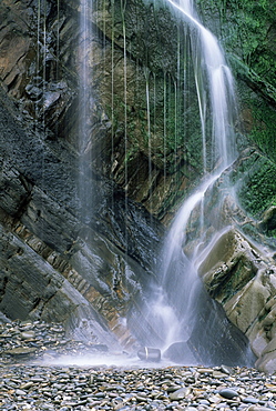 Waterfall with wet rocks and pebbles taken from beach, Cornwall, England, United Kingdom, Europe