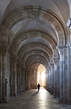 Interior north nave aisle with priest walking away, Vezelay Abbey, UNESCO World Heritage Site, Vezelay, Burgundy, France, Europe