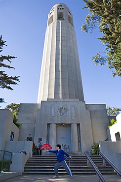 Coit Tower with a Chinese woman performing tai chi fan, San Francisco, California, United States of America, North America