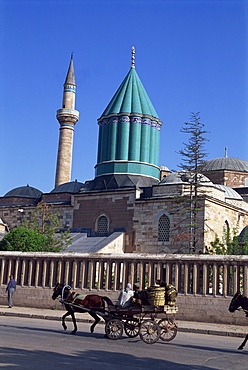 Horse and cart passes the Mevlana Tekke Museum with its green tower and minaret, formerly the monastery, or tekke, of the Whirling Dervishes, at Konya, Anatolia, Turkey, Asia Minor, Eurasia