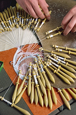 Close-up of hands and bobbins for lace making at Le Puy in the Auvergne, France, Europe