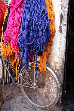 Brightly dyed wool hanging over bicycle, Marrakech, Morrocco, North Africa, Africa