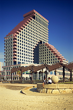 Two women talking on the beach, with the Opera Tower in the background, in Tel Aviv, Israel, Middle East