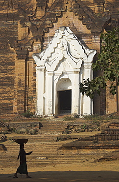 Silhouette of a woman with tray on her head walking past stupa entrance, Mingun Paya, near Mandalay, Myanmar (Burma), Asia