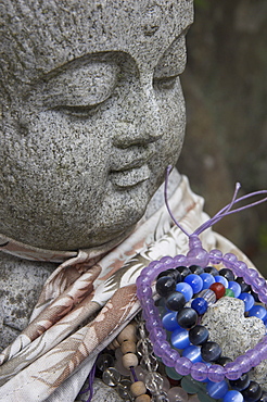 Close up of a traditional stone figure with prayer bracelets, Daisho In temple, Miyajima, Honshu, Japan, Asia