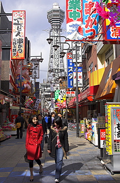 Pedestrian street with young people and Tsutenkaku tower, Shin Sekai neighbourhood, Osaka, Kansai, Honshu, Japan, Asia