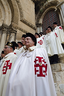 Members of the Order of the Holy Sepulchre pausing in full dress at the Holy Sepulchre, Jerusalem Old City, Israel, Middle East