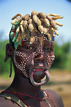 A member of the Mursi Tribe with lip plates, head dress and body paint in Mago National Park, Ethiopia, Africa