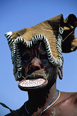 A member of the Mursi Tribe with lip plates, head dress and body paint in Mago National Park, Ethiopia, Africa