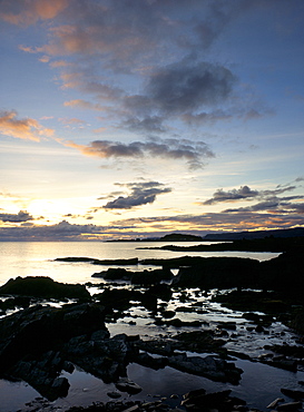 Rocky coastline at dusk, looking along the coast to Easdale Island, Seil Island, Argyll and Bute, Scotland, United Kingdom, Europe