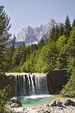 View across waterfall over weir on River Velika Pisnca to Prisank mountain, Triglav National Park, Julian Alps, Kranjska Gora, Dolina, Slovenia, Europe