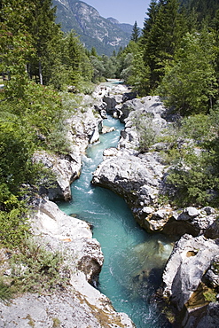 Soca River with clear emerald water flowing between eroded rocks in Trenta Valley in summer, Triglav National Park, Julian Alps, Slovenia, Europe