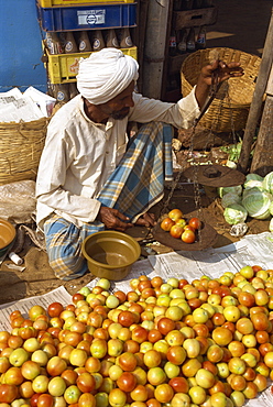 Man weighing tomatoes on scales, Mapusa Market, Goa, India, Asia