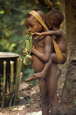 Pygmy girl carrying a young boy, Central African Republic, Africa