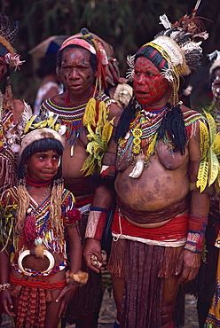 Portrait of two women and a girl with facial decoration and wearing jewellery and head-dresses, in Papua New Guinea, Pacific Islands, Pacific