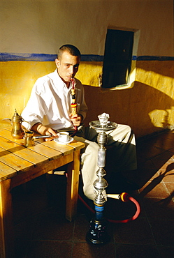 Man smoking a waterpipe in a restaurant, Madaba, Jordan 