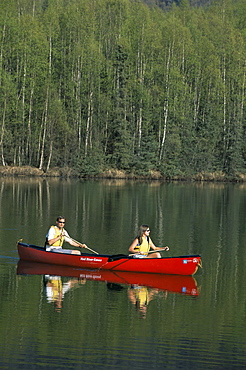 Man and woman canoeing in Mirror Lake, Chugach Mountains, Anchorage, Alaska, United States of America, North America