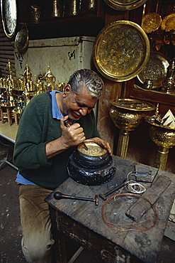 Portrait of a craftsman at work in a copper souk, Khan el Khalili Bazaar, Cairo, Egypt, North Africa, Africa