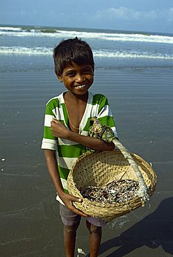 Boy with basket on the beach, Cox's Bazaar, Bangladesh, Asia