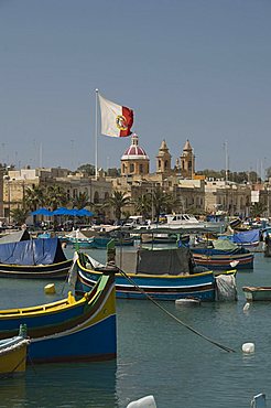 Brightly coloured fishing boats called Luzzus at the fishing village of Marsaxlokk, Malta, Mediterranean, Europe