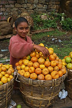 Head and shoulders portrait of a young woman, smiling and looking at the camera, a roadside fruit vendor near Kodaikanal, Tamil Nadu, India, Asia