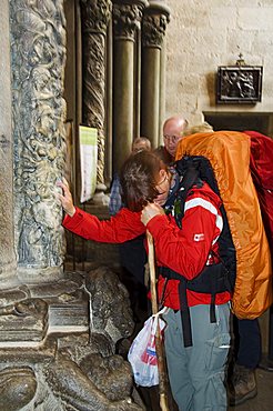 Pilgrims touching a column on the Porch of La Gloria, Santiago Cathedral, Santiago de Compostela, Galicia, Spain, Europe