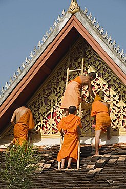 Monks on roof painting the temple decorations, Wat Mai, Luang Prabang, Laos, Indochina, Southeast Asia, Asia