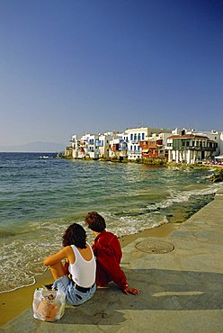 Couple looking towards Little Venice in the Alefkandra district of Mykonos Town, Mykonos, Cyclades Islands, Greece, Europe