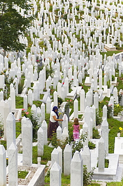 Muslim woman and child tend a grave at a war cemetery, Sarajevo, Bosnia, Bosnia-Herzegovina, Europe