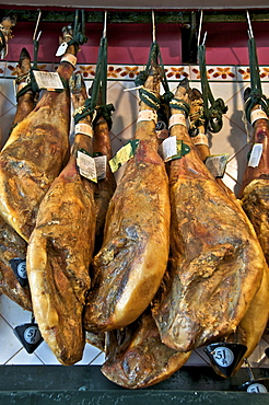 Spanish hams hanging in a restaurant bodega, Seville, Andalusia, Spain, Europe