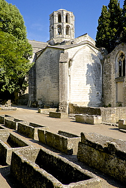 Gallo-roman sarcophagi, Alyscamps, gallo-roman necropolis, and the lantern steeple of the 12th century Saint Honorat church,¬† Arles, Bouches du Rhone, Provence, France, Europe