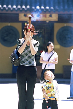 Young woman praying, Longhua temple, Shanghai, China, Asia