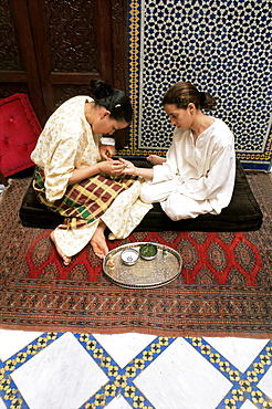 Applying a design to a young woman's hand, Fez, Morocco, North Africa, Africa