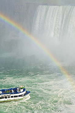 Maid of the Mist tour excursion boat under the Horseshoe Falls waterfall with rainbow at Niagara Falls, Ontario, Canada, North America