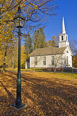 Autumn fall colours around traditional white timber clapperboard church, Grafton, Vermont, New England, United States of America, North America