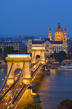 Night view of the Chain Bridge (Szechenyi Lanchid), illuminated, over the River Danube with the Gresham Hotel, St. Stephen's basilica, and the Pest side behind, Budapest, Hungary, Europe