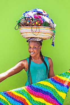 Local woman with basket on her head selling souvenir scarves and jewellery, Espargos, Santa Maria, Sal island, Cape Verde, Africa