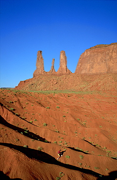 Rock climber in huge landscape, Three Sisters, Monument Valley, Navajo Reserve, Arizona/Utah, USA